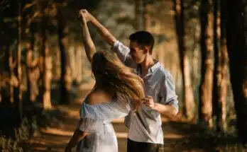 man and woman dancing at center of trees