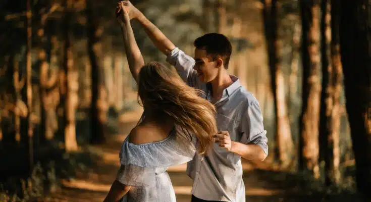 man and woman dancing at center of trees